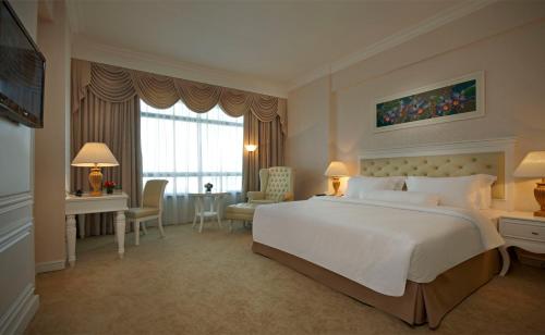 a hotel room with a large white bed and a desk at Royale Chulan Damansara in Petaling Jaya