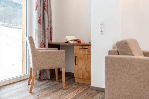 a room with a desk and a chair and a window at Aktivhotel Pehab in Ramsau am Dachstein