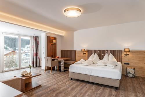a hotel room with a bed and a dining room at Aktivhotel Pehab in Ramsau am Dachstein