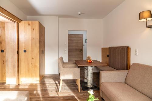 a living room with a couch and a table at Aktivhotel Pehab in Ramsau am Dachstein