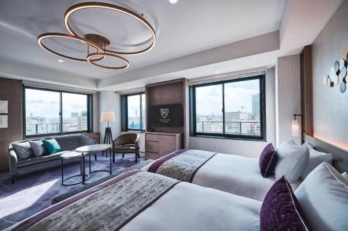 a hotel room with two beds and a couch at The Royal Park Canvas - Kobe Sannomiya in Kobe