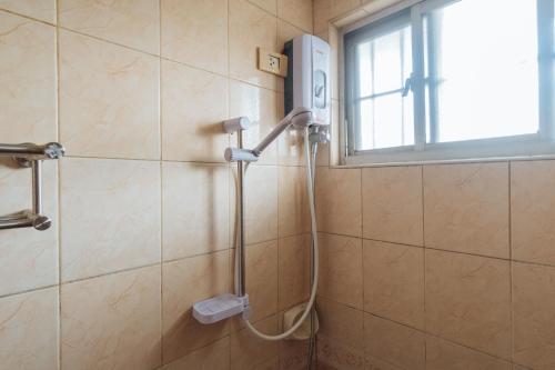 um chuveiro na casa de banho com uma janela e uma cabeça de chuveiro em Dechmark Hotel em Manila