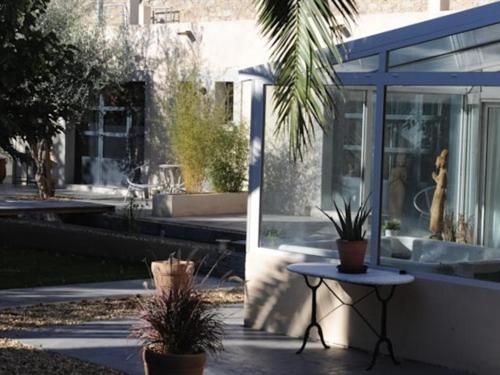a patio with a table and some plants and a building at Chambre d'Hôtes Villa Ambrosia in Narbonne