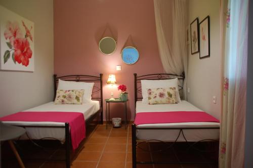 - 2 lits dans une chambre aux murs roses dans l'établissement Domenica Apts II, à Laganas