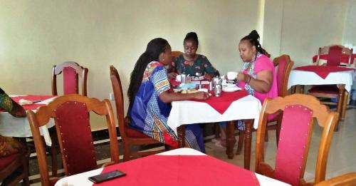a group of three women sitting at a table at Bomen Hotel in Isiolo