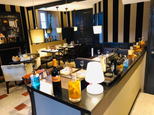 a bar in a restaurant with bottles of alcohol on it at Aux 13 Arches-Logis Hôtel Restaurant in Portbail