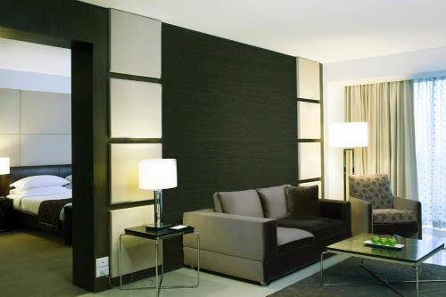 a hotel room with a couch and a bed at Radisson Blu Hotel Pune Kharadi in Pune