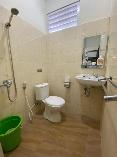 a bathroom with a toilet and a sink at Omah Inap D24 Syariah near Universitas Aisyiah Yogyakarta Mitra RedDoorz in Sleman