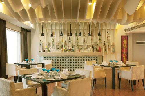 a restaurant with tables and chairs and a bar at Radisson Blu Hotel Pune Kharadi in Pune