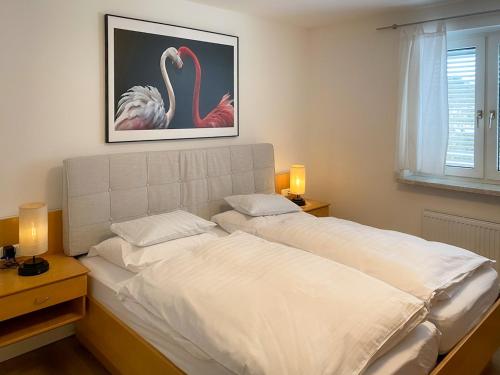 1 dormitorio con 1 cama grande y 2 flamencos rosas en Comfortapartment LEONDING en Leonding