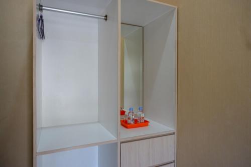 a white cabinet with a mirror and bottles in it at RedDoorz @ Jalan Majapahit Semarang in Alastuwo
