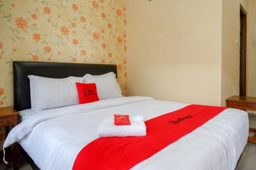 a bed with red and white towels on it at RedDoorz @ Jalan Majapahit Semarang in Alastuwo