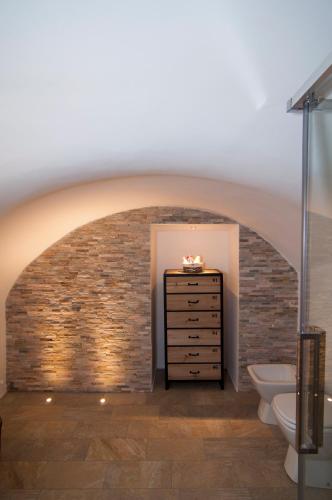 a bathroom with a brick wall and a sink and toilet at B&B Torino Très Chic in Turin