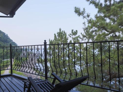 a balcony with a wrought iron fence and chairs at ISANA Resort in Ito