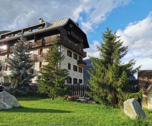 a building with a fence next to two trees at La Stua Livigno in Livigno