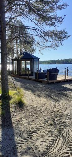 een klein gebouw op een strand met een boot bij Lomakylä Atimo in Alakitka