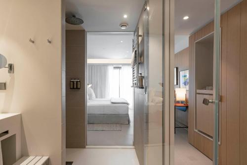 a bathroom with a glass door leading to a bedroom at Parador de Aiguablava in Begur