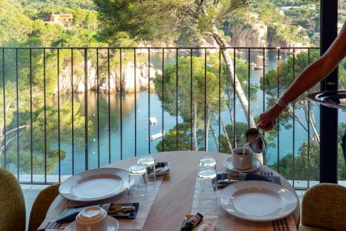 a table with a view of a river from a balcony at Parador de Aiguablava in Begur