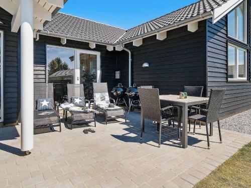 a patio with chairs and a table and a grill at 16 person holiday home in Hasselberg in Kappeln