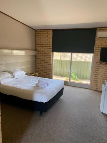 a bedroom with a large bed and a large window at HOPETOUN COMMUNITY HOTEL MOTEL in Hopetoun
