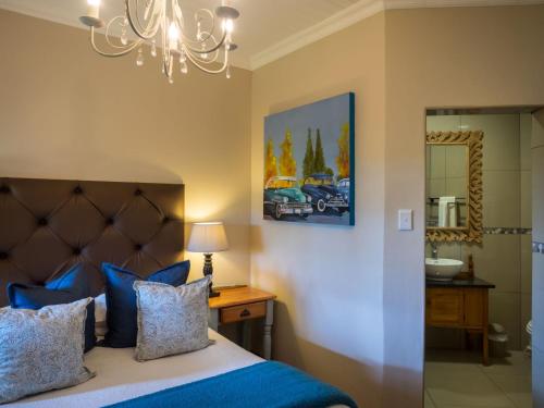 a bedroom with a bed and a chandelier at Fouriesburg Country Inn in Fouriesburg
