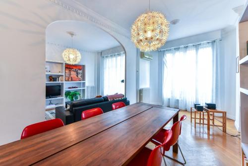 - un salon avec une table en bois et des chaises rouges dans l'établissement Le Maréchal, à Nice