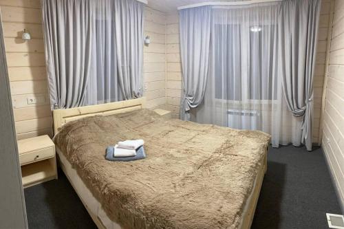 1 dormitorio con 1 cama con 2 toallas en Дзембронія en Dzembronia