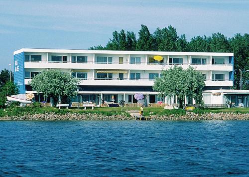 um grande edifício na costa de uma massa de água em Haus am See - Steinwarder HAS-022 Haus am See em Heiligenhafen