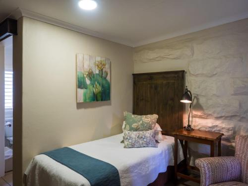 a bedroom with a bed and a table with a chair at Fouriesburg Country Inn in Fouriesburg