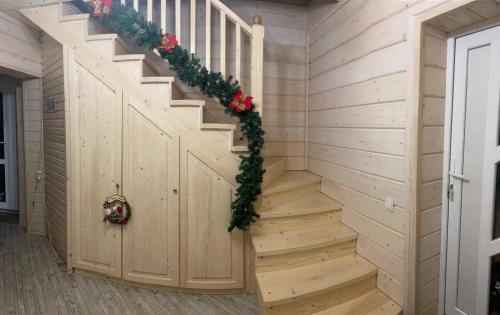 a wooden staircase in a house with a christmasreath at Дзембронія in Dzembronia