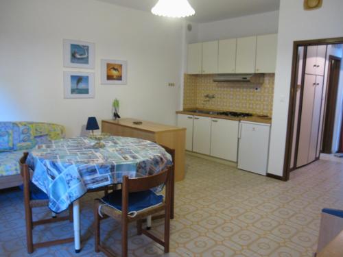a kitchen and dining room with a table and a couch at Argea in Grado
