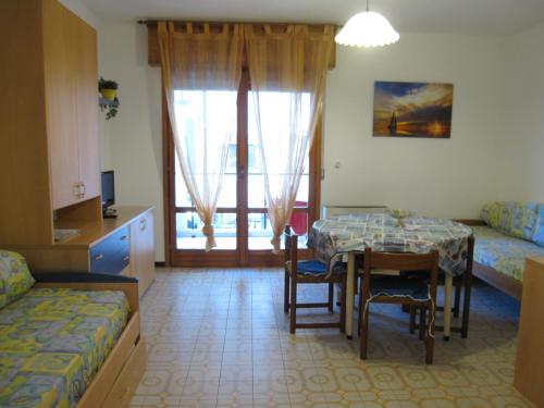 ein Zimmer mit einem Tisch und ein Schlafzimmer mit einem Bett in der Unterkunft Argea in Grado