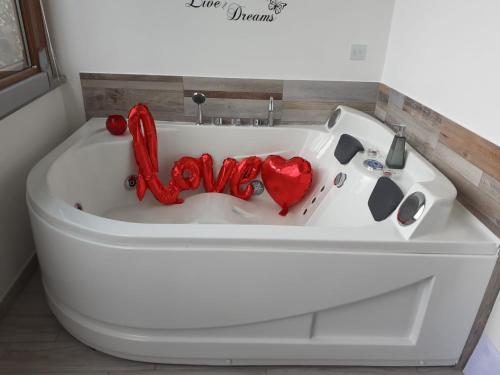 a white bath tub with a love sign in it at La casa nel Borgo Sospeso "con vasca e vista panoramica" in Vitorchiano