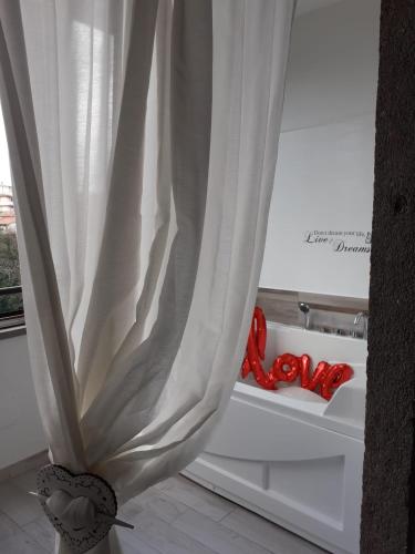 a white curtain in a kitchen with red decorations at La casa nel Borgo Sospeso "con vasca e vista panoramica" in Vitorchiano