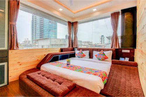 a bedroom with a large bed and a large window at Hotel Radana Vashi Navimumbai in Navi Mumbai