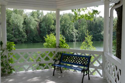 a blue bench sitting on a porch overlooking a river at Nelijärve Holiday Centre in Aegviidu
