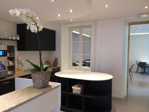 a kitchen with a table and a vase with white flowers at Hôtel de l'Ecluse in Neuchâtel