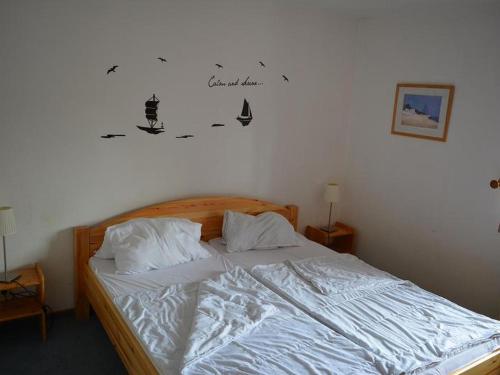 a bedroom with a bed with two pillows and a sign on the wall at Ferienwohnung Wilde in Hooksiel