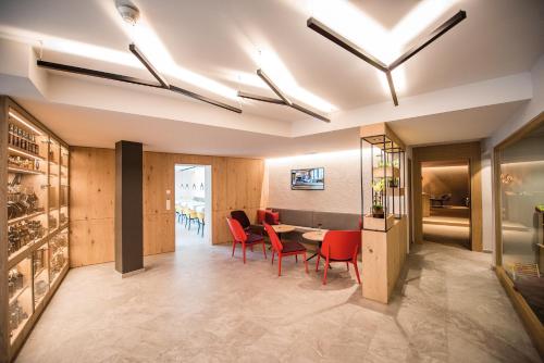 a dining room with red chairs and a table at Dining & Living Alpenrose in Bressanone