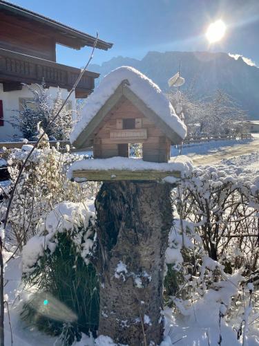 a bird house with snow on top of it at Tirol Appartements Schwaiger in Niederndorf