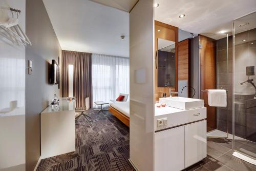a bathroom with a white sink and a shower at LÉGÈRE HOTEL Luxembourg in Luxembourg