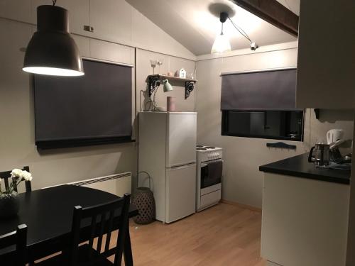 a kitchen with a refrigerator and a table and a television at Hekla Nordicabin - Wild Cottage in Hella
