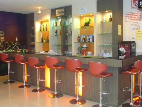 a bar with red stools in a restaurant at S2 Hotel in Seremban
