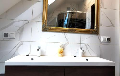a bathroom with a white sink and a mirror at Luksusowe domy na Mazurach nad jeziorem 1 in Kruklanki