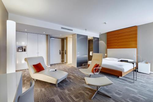 ein Hotelzimmer mit einem Bett, einem Schreibtisch und Stühlen in der Unterkunft LÉGÈRE HOTEL Luxembourg in Luxemburg (Stadt)