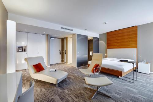 a hotel room with a bed and a desk and chairs at LÉGÈRE HOTEL Luxembourg in Luxembourg