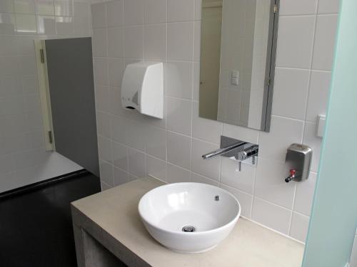 a bathroom with a white sink and a mirror at Azores Youth Hostels - Sao Miguel in Ponta Delgada