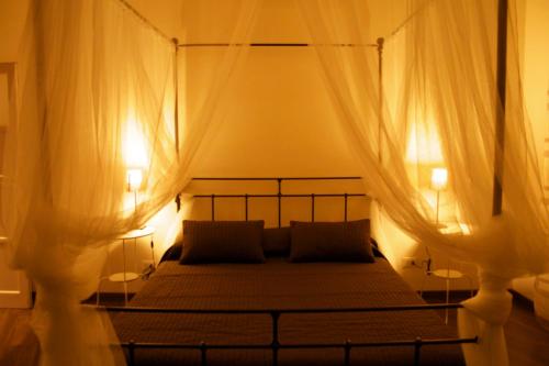 ボローニャにあるB&B Casa Bolognaのベッドルーム1室(天蓋付きベッド1台、ランプ2つ付)