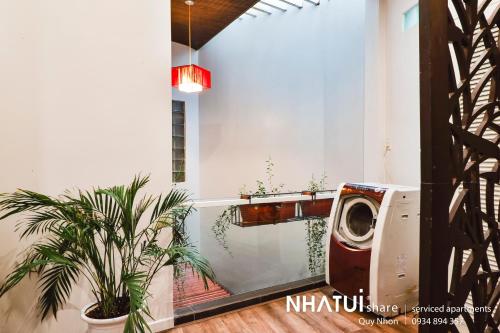a washing machine in a room with plants at NHATUIshare Quy Nhơn in Quy Nhon