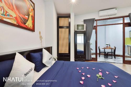 a bedroom with a blue bed with flowers on it at NHATUIshare Quy Nhơn in Quy Nhon